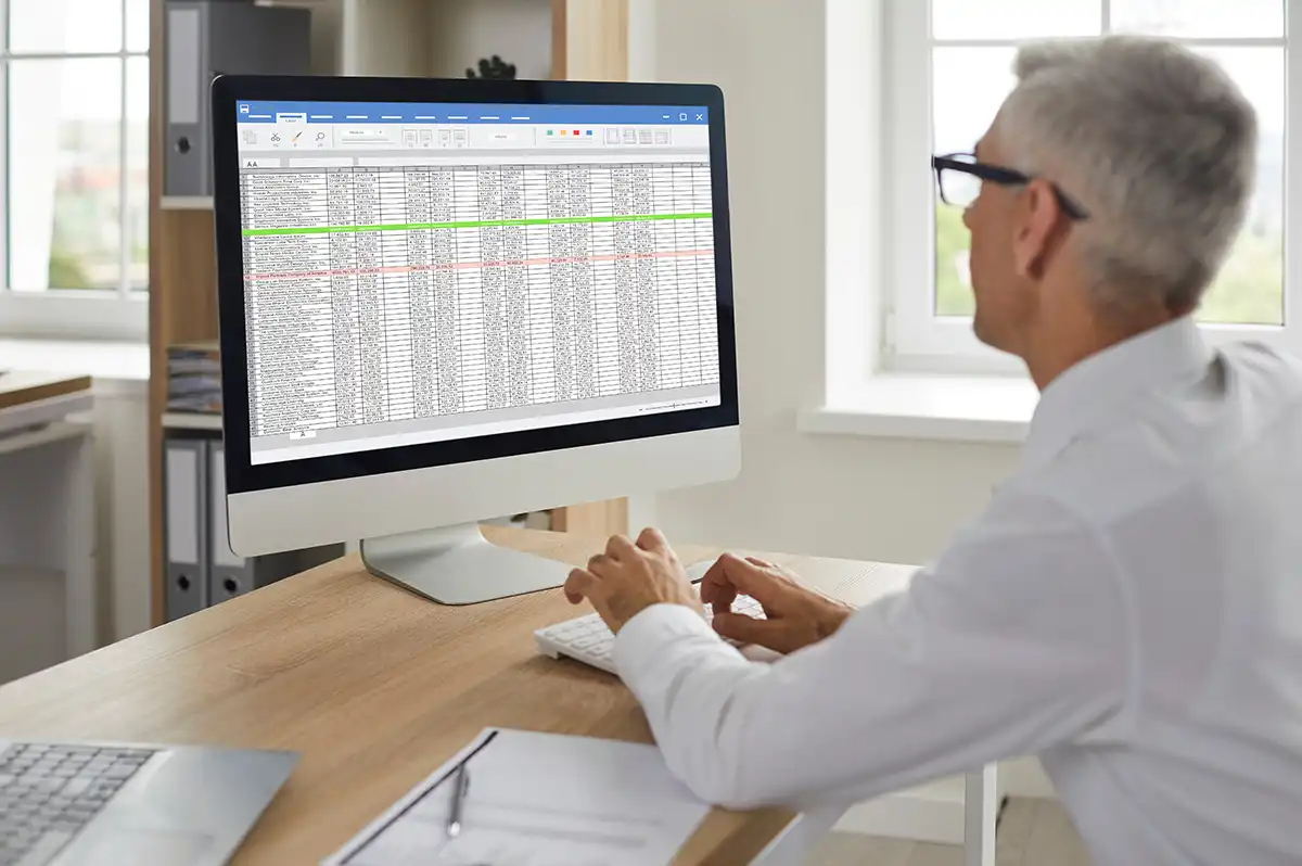 Business person sitting at desk analyzing spreadsheet data. Cost segregation study helps real estate owners accelerate depreciation.